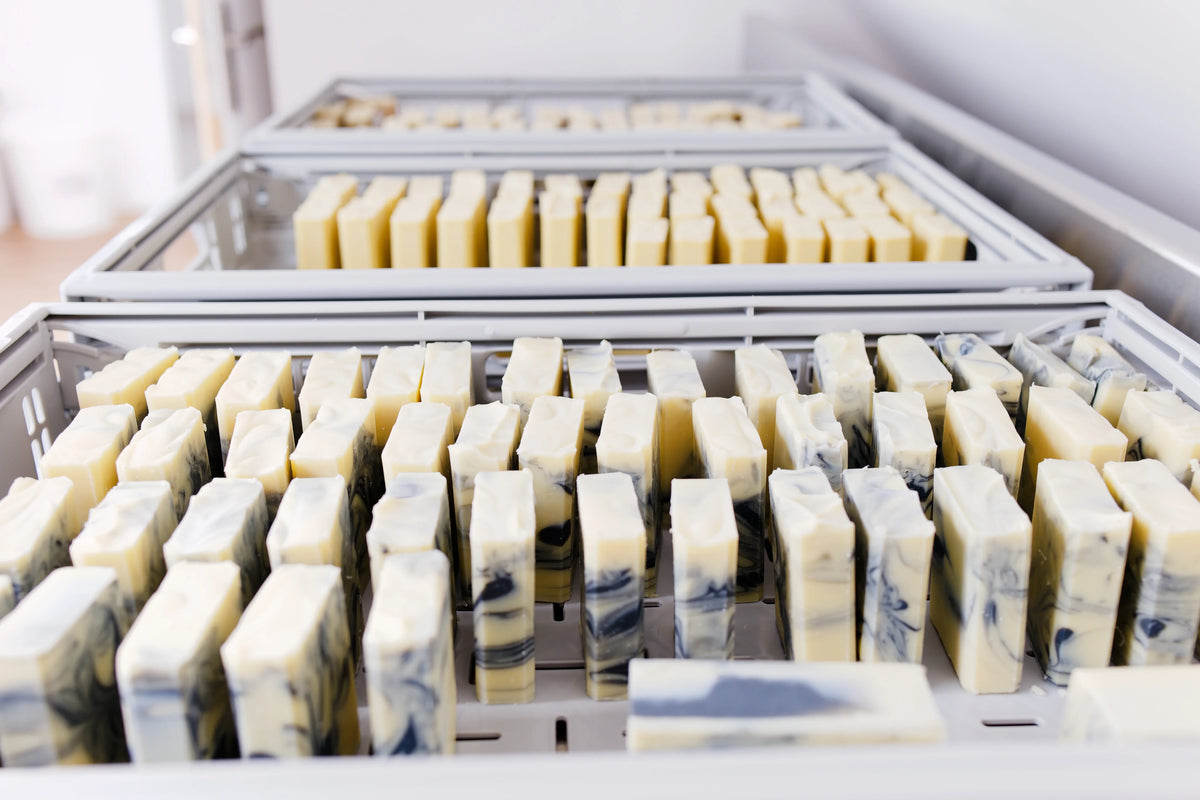 Savon artisanal Moussaillon, surgras à 6%, naturel et sans parfum, disposé en bacs de séchage.