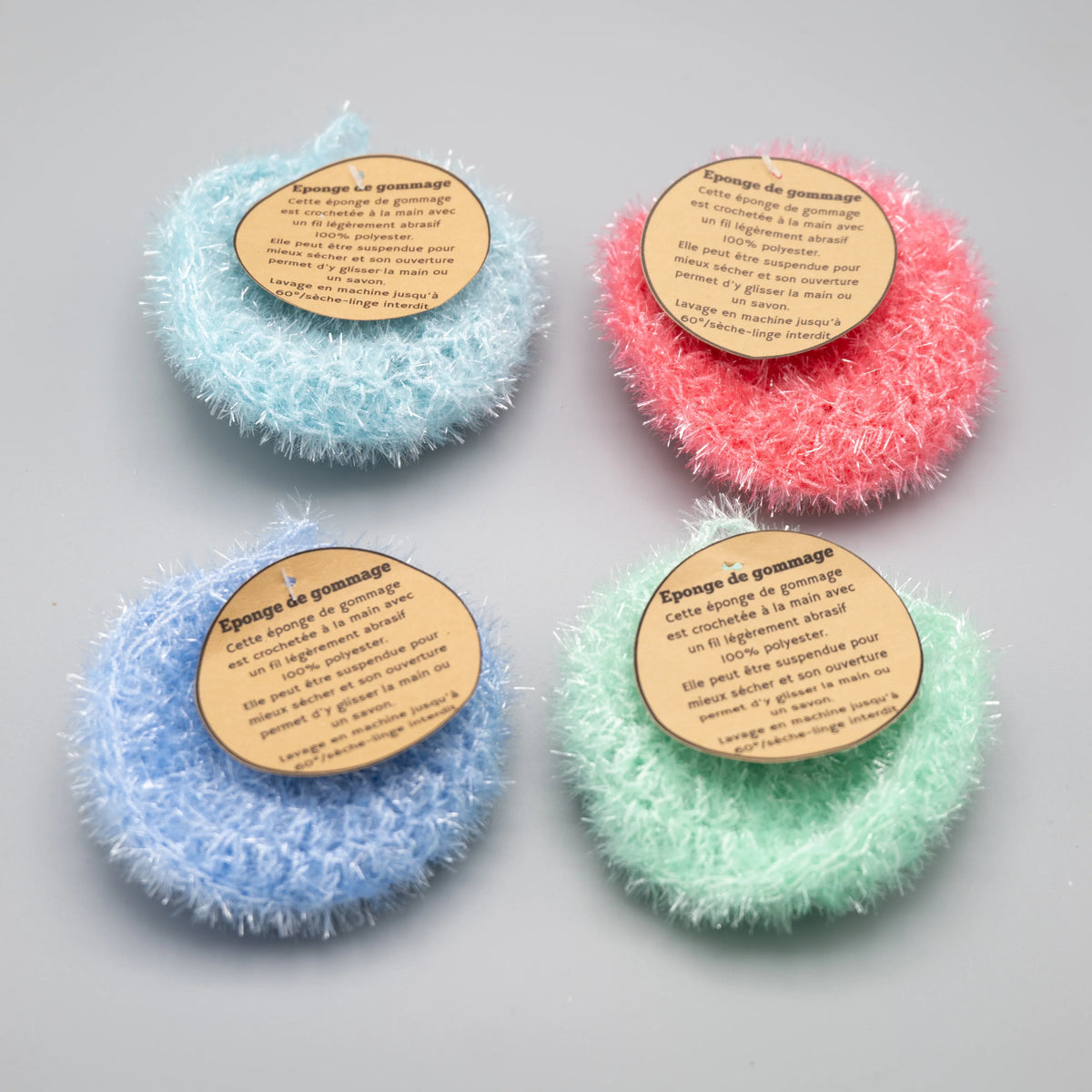 Lot de quatre éponges de gommage Mam'zelle Lily de couleurs pastel.